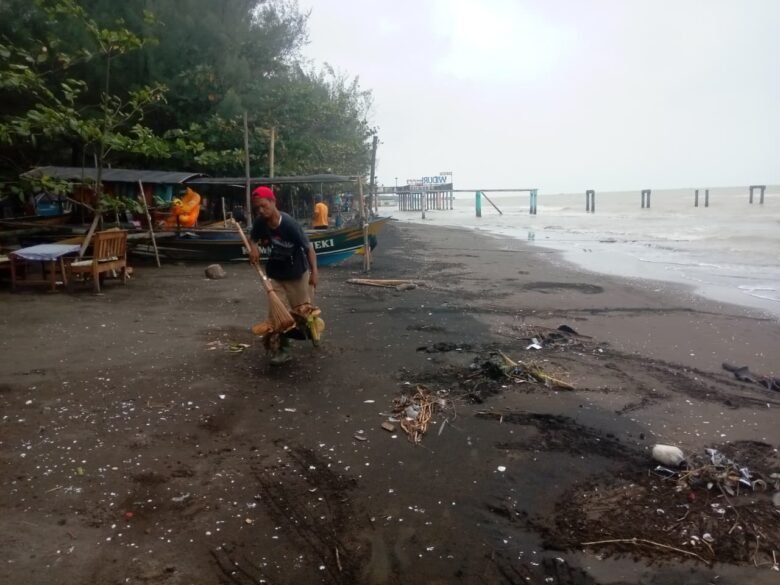 Pekerja dari Dinas Pariwisata dan Kebudayaan Pemalang membersihkan sampah di Pantai Widuri