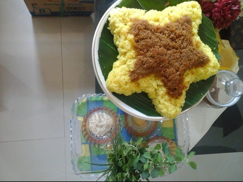 Beras kuning dan air tepung tawar digunakan sebagai simbol doa dan keberkahan dalam prosesi peusijuk.