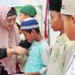 Ketua PIMAJT Hj Nur Kusuma Dewi Noor Achmad saat menyerahkan santunan kepada anak yatim
