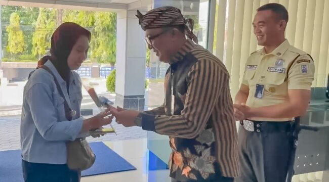 Pemimpin Cabang BRI Pemalang, David A. Saxono memberikan bunga mawar dan cokelat kepada para nasabah yang datang pertama untuk bertransaksi di Hari Pelanggan Nasional 2025